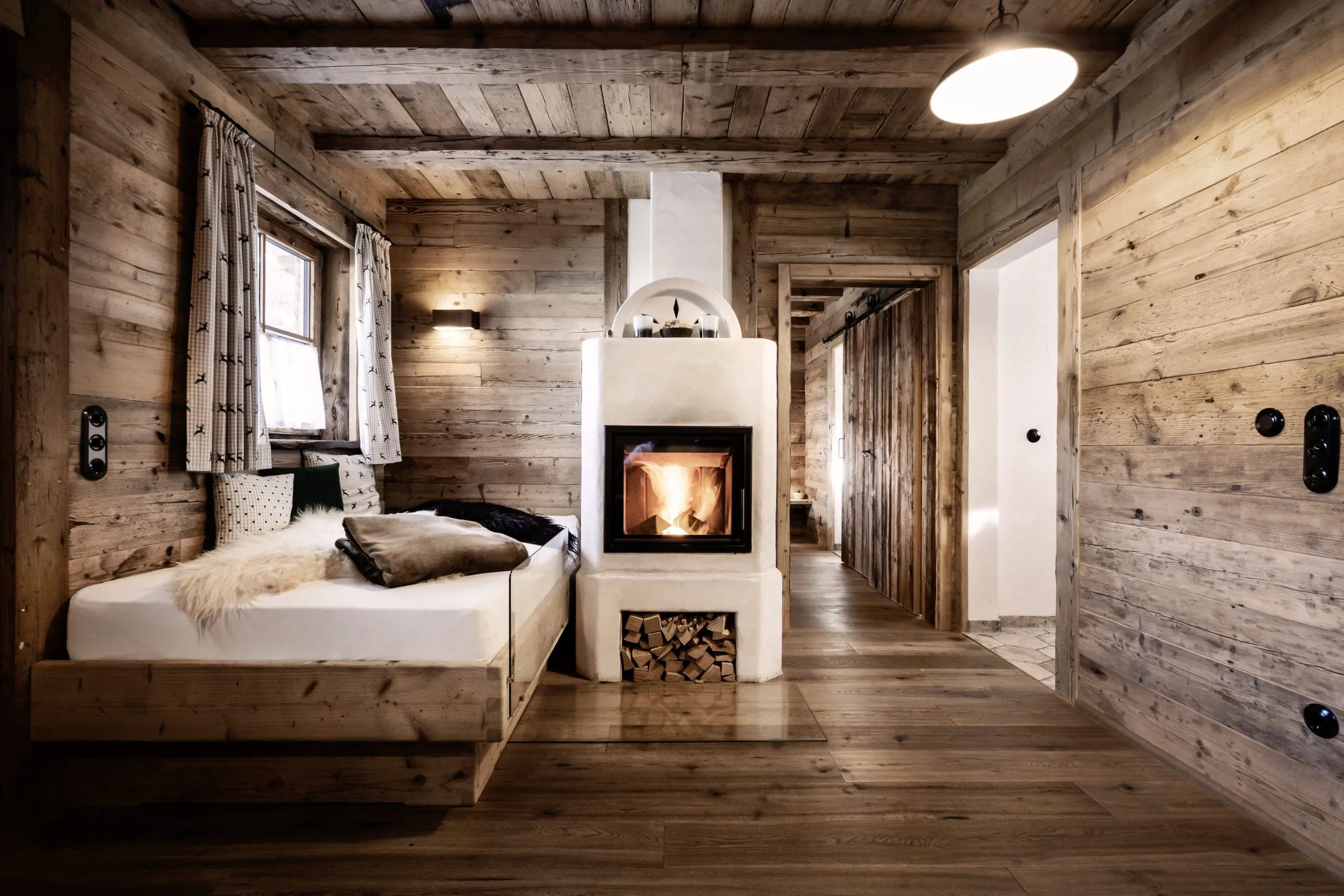 Wohnraum in den Alpin Chalets Oberjoch mit loderndem Kamin und Tagesbett