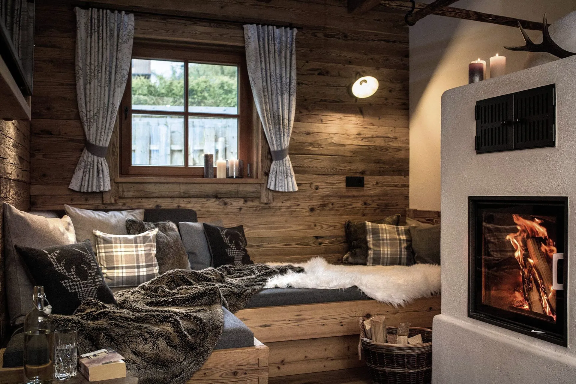 prasselnder Kamin vor dem Kuschelsofa in den Alpzitt Chalets