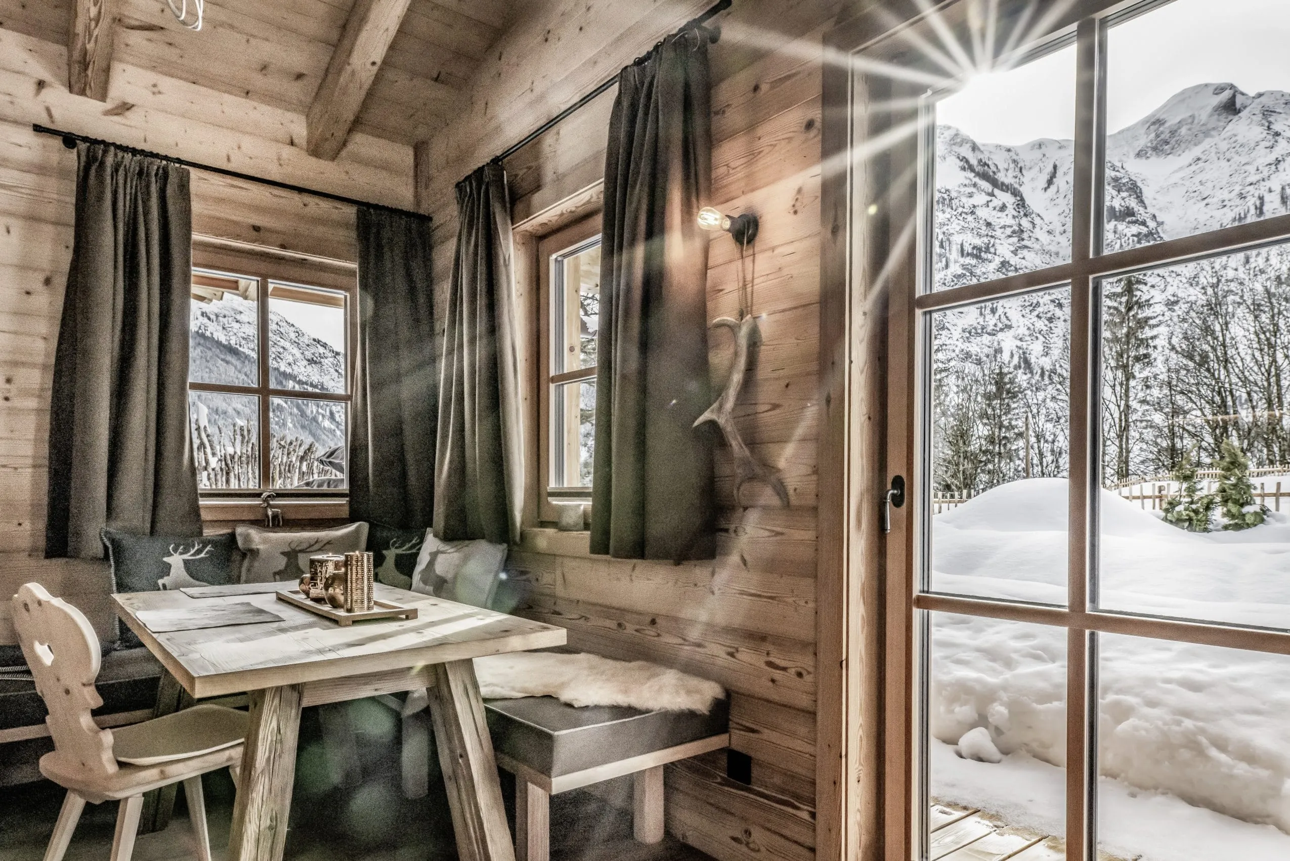 Esstisch mit Blick auf die verschneite Landschaft im Benglerwald Chaletdorf