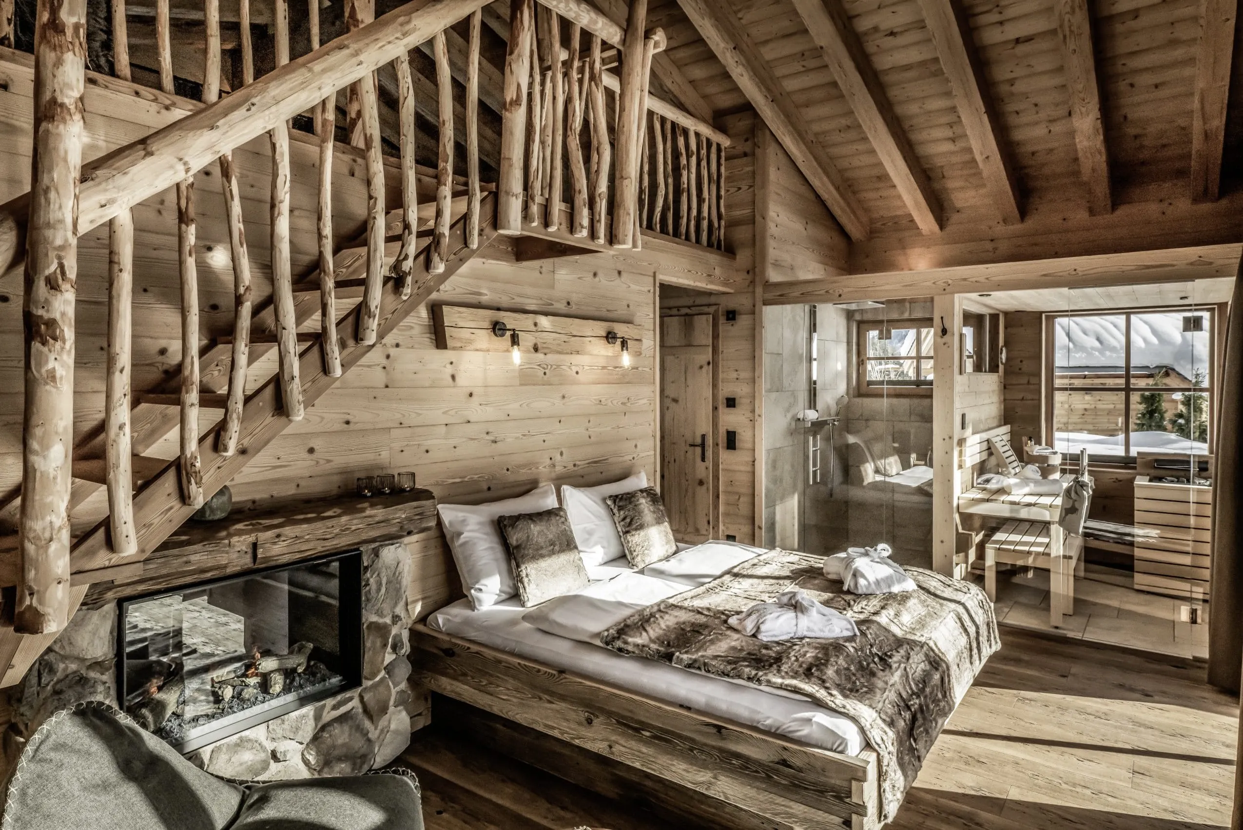 rustikaler Schlafbereich im Benglerwald Chaletdorf mit Altholztreppe und Privater Sauna