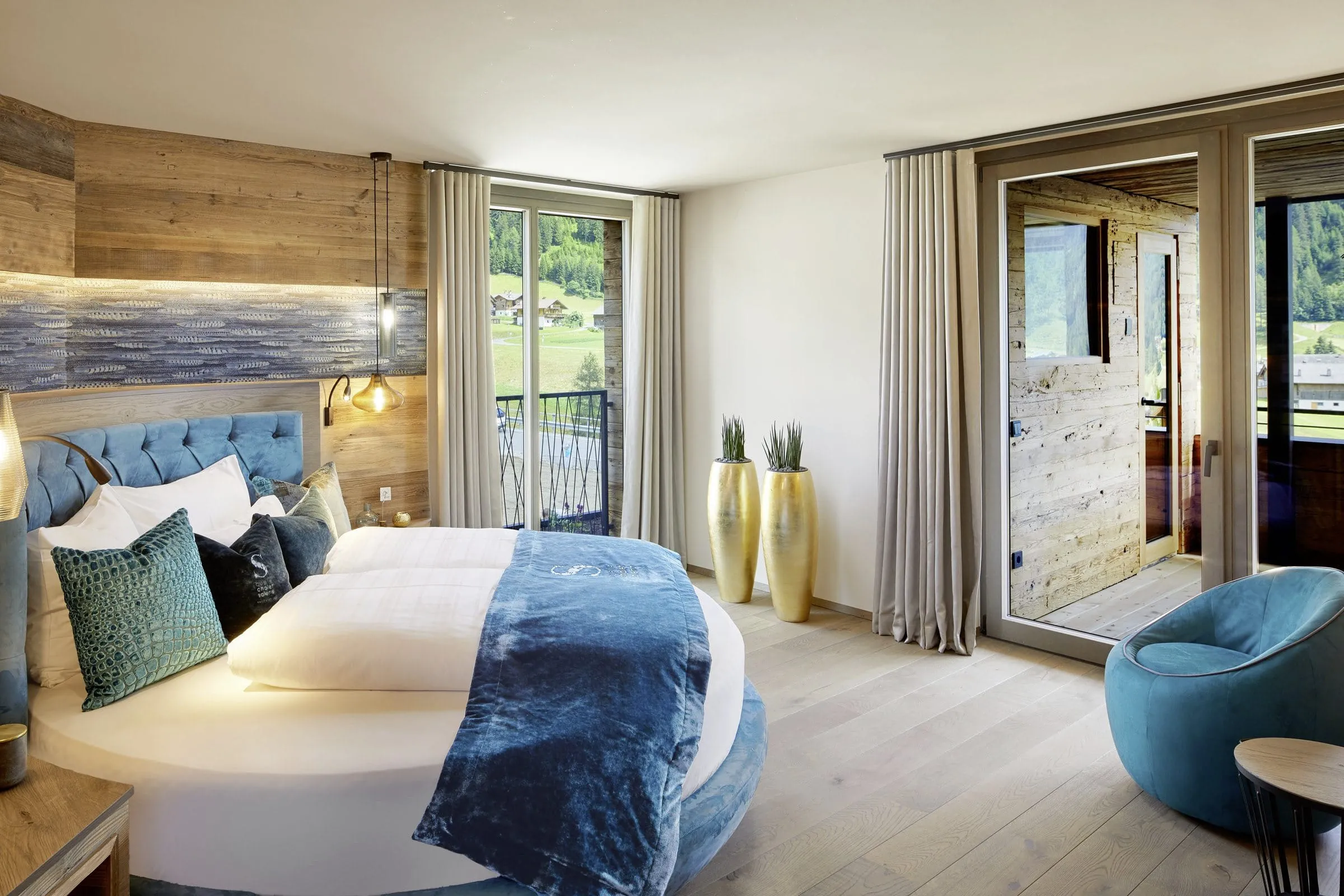 rundes Bett mit t&uuml;rkisem Bett&uuml;berwurf im Chalet Salena