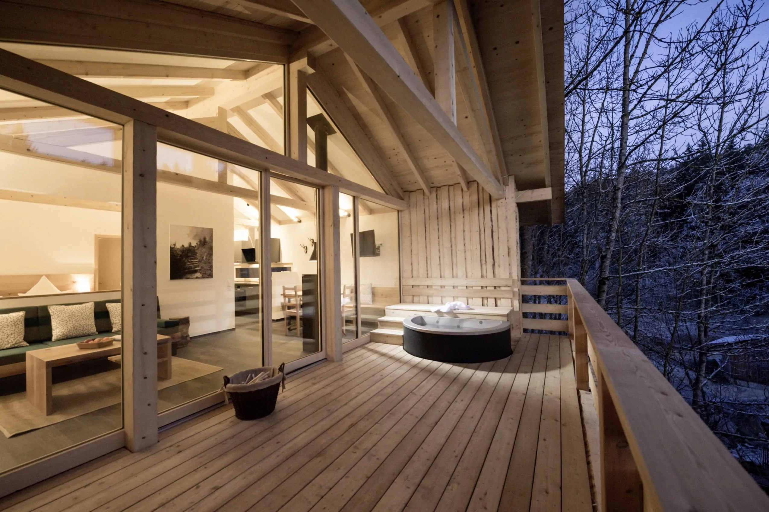 Whirlpool auf der Terrasse vor dem gem&uuml;tlichen Wohnraum des Chalets im Forstgut