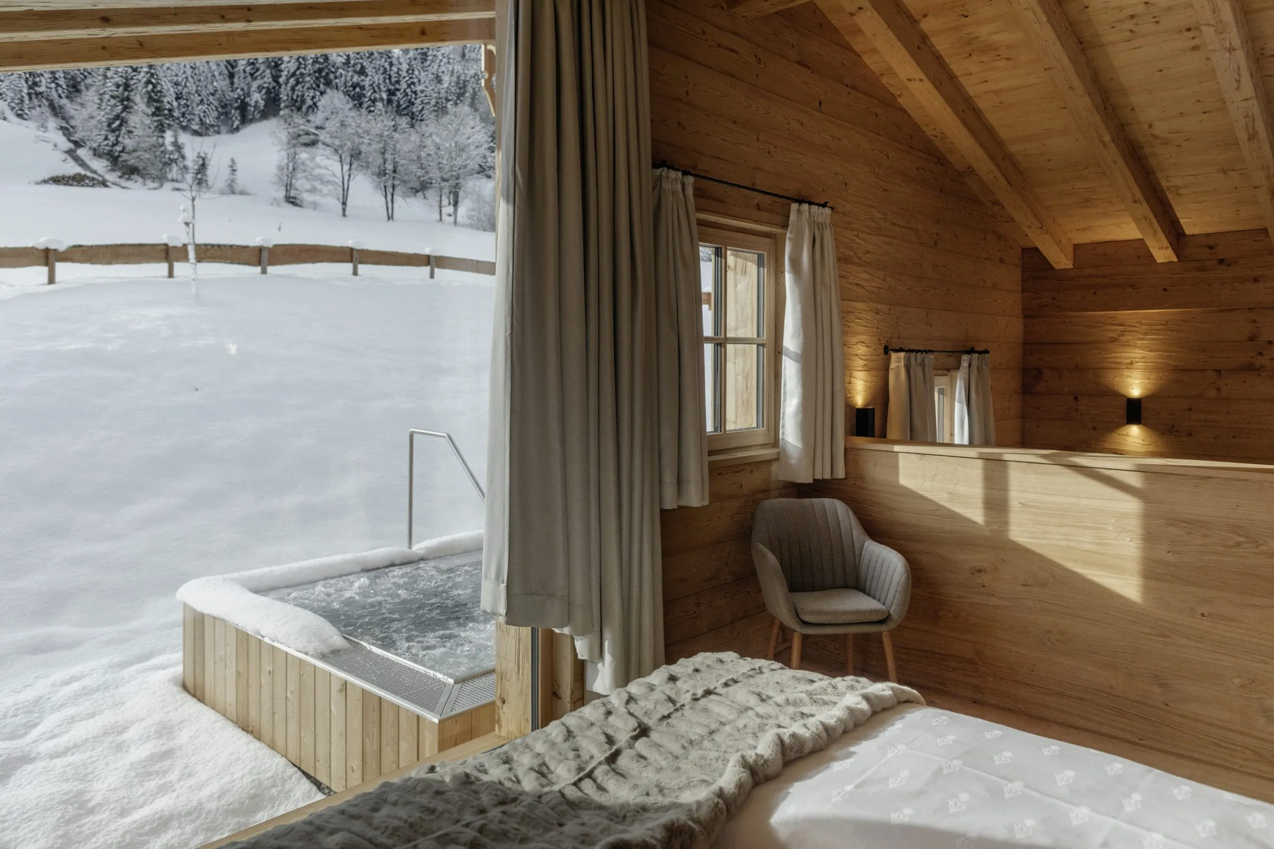Chalet mit Outdoor-Whirlpool im Schnee der Hygna Chalets