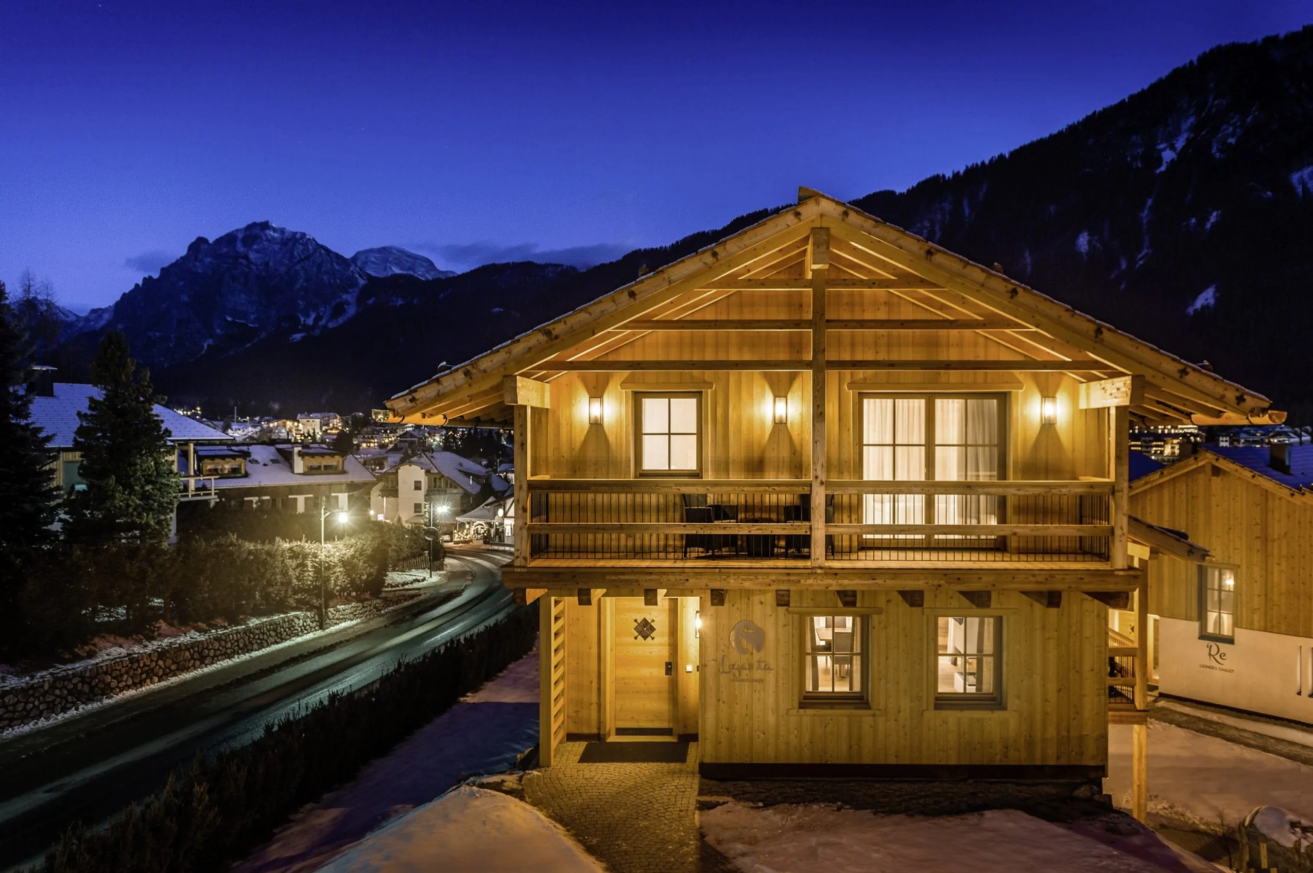 beleuchtetes Haus der Liondes Chalets bei Nacht neben der Stra&szlig;e