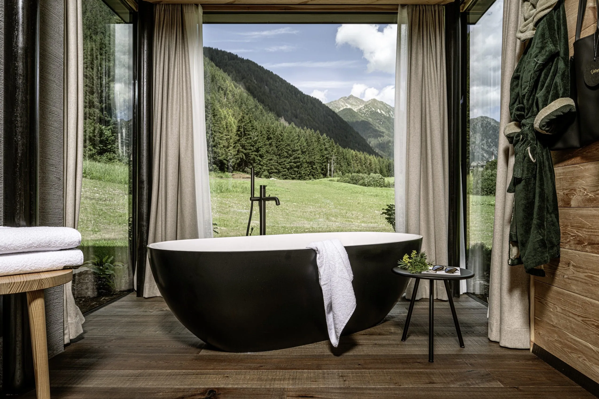 freistehende schwarze Badewanne vor Panoramafenster der S&uuml;dtirol Chalets Valsegg