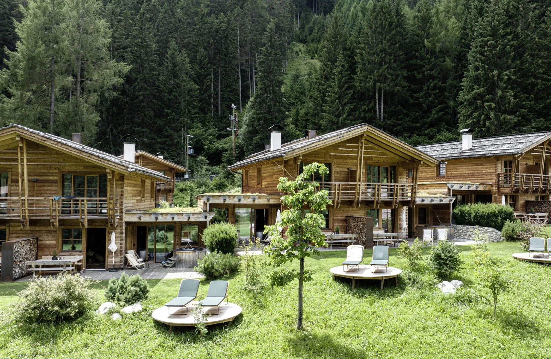 Südtirol Chalets Valsegg von außen mit Ruheliegen auf runden Holzplattformen