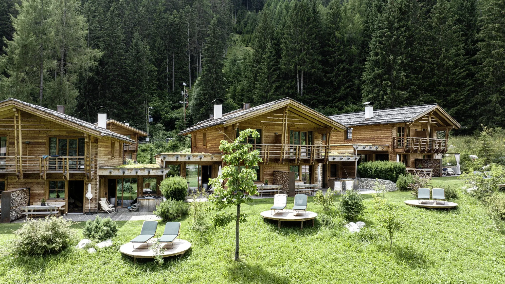 Südtirol Chalets Valsegg von außen mit Ruheliegen auf runden Holzplattformen