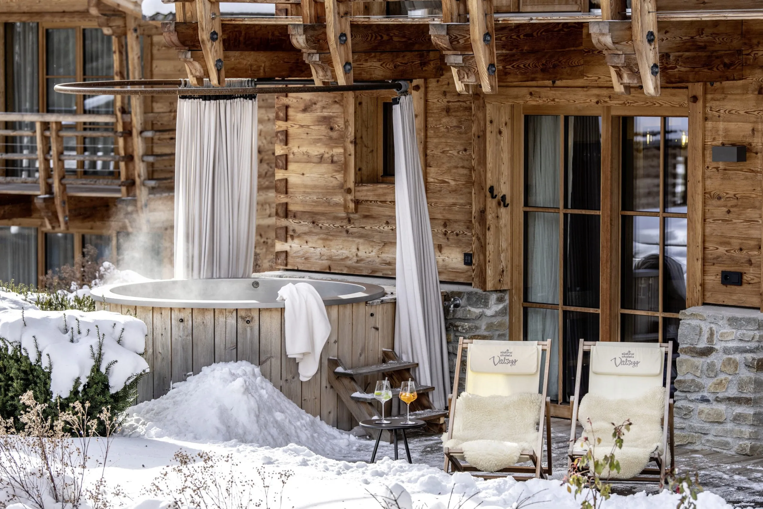 Whirlpool mit rundem Vorhang auf der Terrasse der S&uuml;dtirol Chalets Valsegg im Schnee