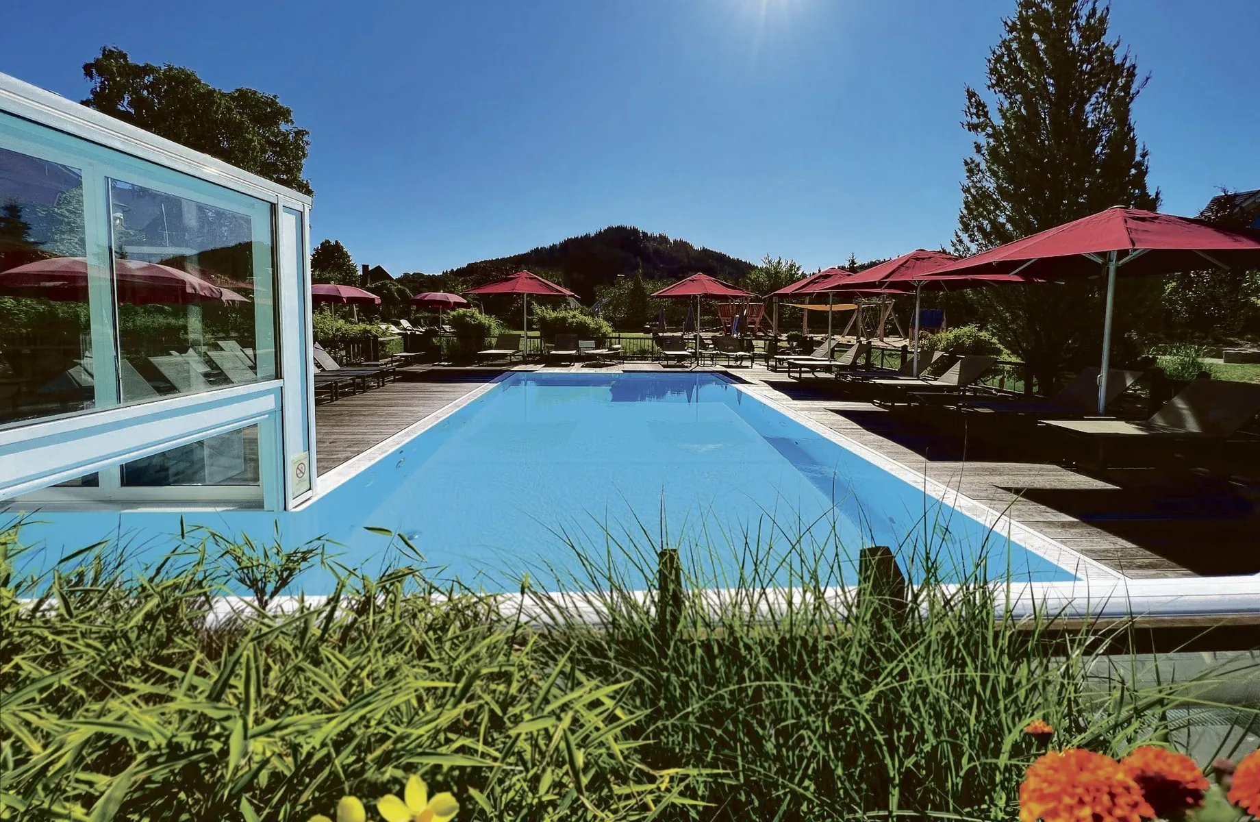 Outdoorpool im Sonnenpark Willingen mit roten Sonnenschirmen