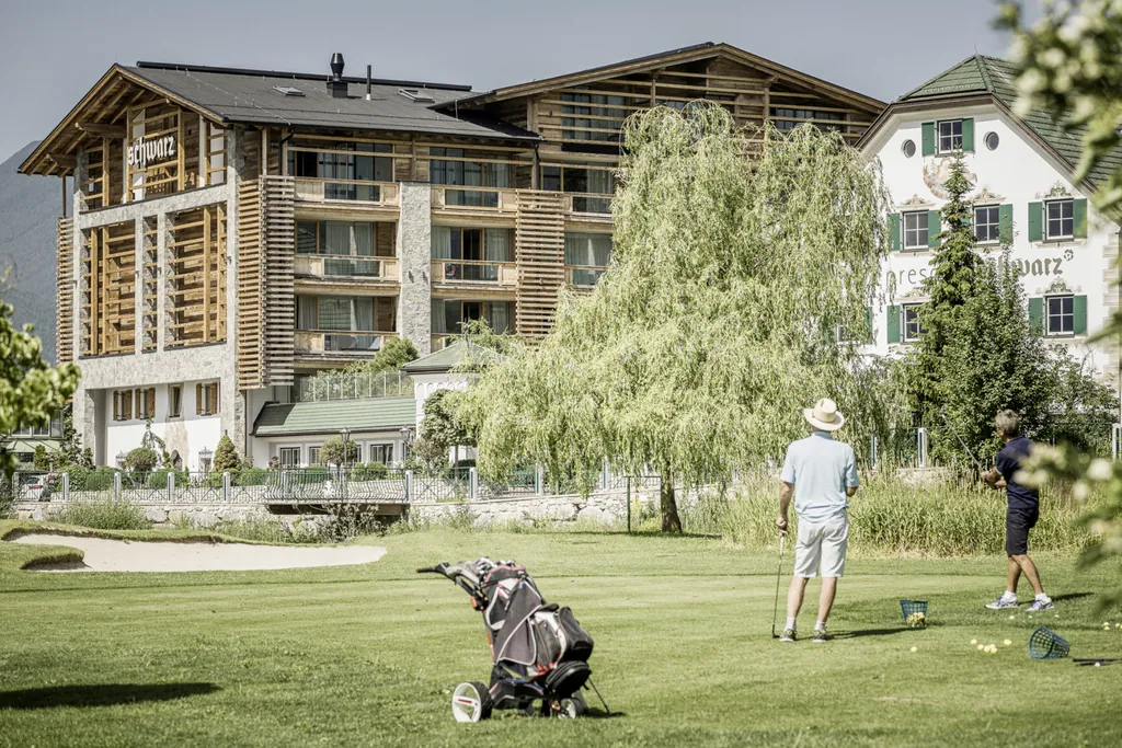 Zwei Golfspieler üben auf dem Golfplatz vor dem Golfhotel Alpenresort Schwarz