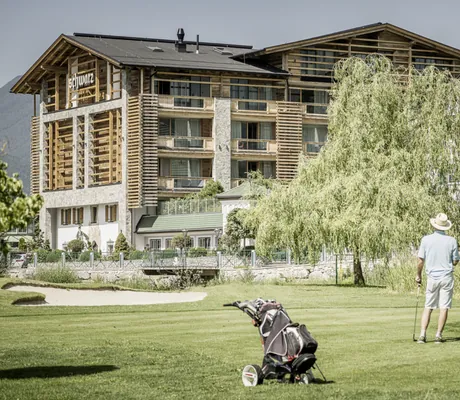 Zwei Golfspieler üben auf dem Golfplatz vor dem Golfhotel Alpenresort Schwarz