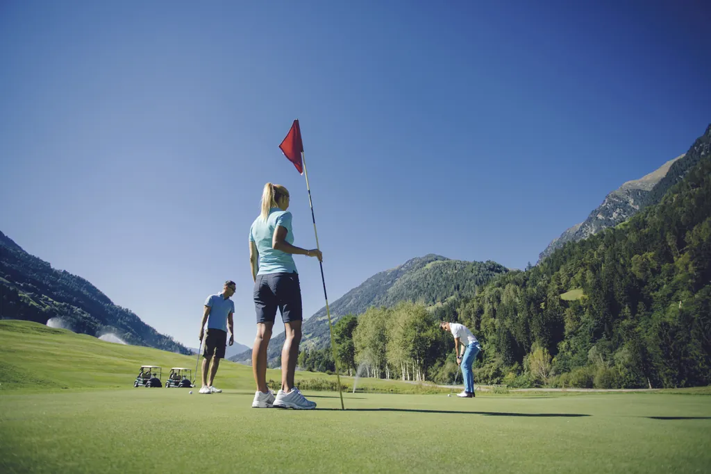 Drei Personen spielen auf dem Golfplatz Passeier.Meran