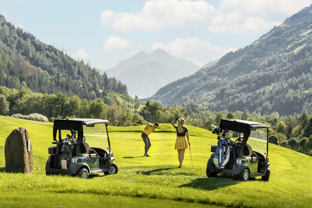 Junges Pärchen in modischer Kleidung spielt auf dem Golfplatz Passeier.Meran