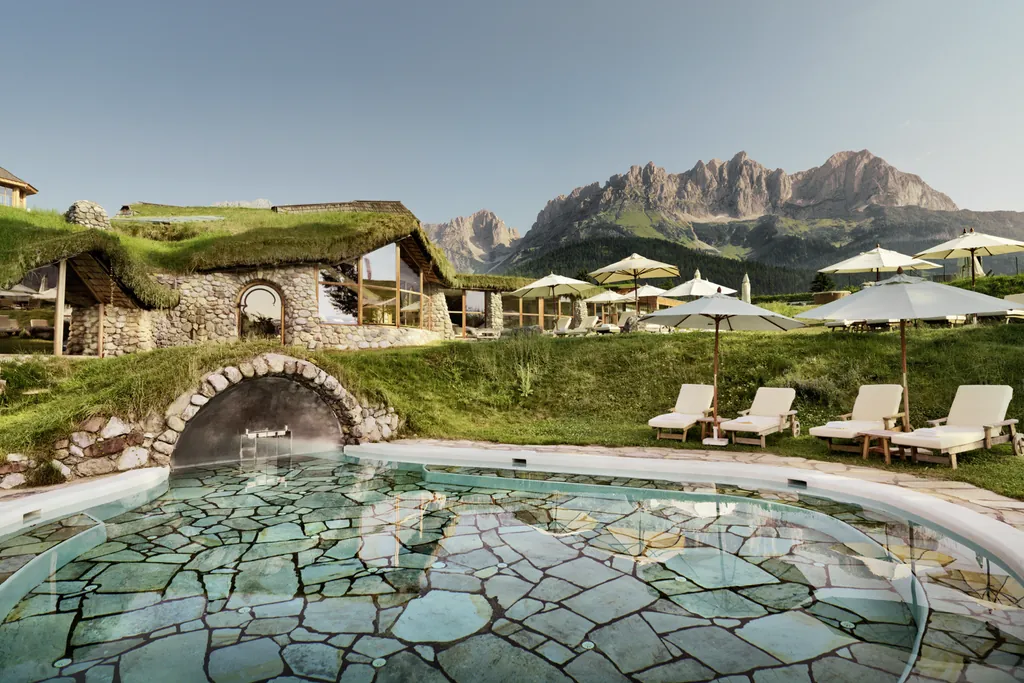 Outdoorpool im Golfresort Stanglwirt mit Bergpanorama im Hintergrund