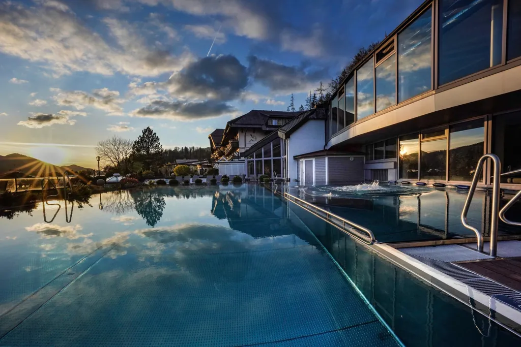 Outdoorpool des Ebner’s Waldhof am See Alpines Spa und Golf Resort in der Abendstimmung