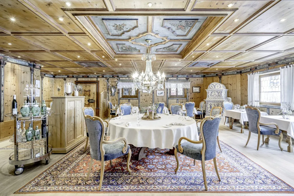 Paznaunerstube im elegant Alpenl&auml;ndischen Stol mit historischem Kachelofen, Perserteppich, Holzdecken- und -Wandvert&auml;felung im Trofana-Royal