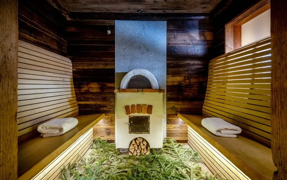 Sauna mit Sitzbänken und Tannenzweigen auf dem Boden im Wellnesshotel DAS STEMP im Bayerischen Wald