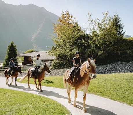 Drei reitende Kinder auf Haflingern in der Hotelanlage des Familienresort Buchau am Achensee