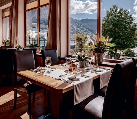 Gedeckte Tische im Restaurant des Familienresorts Buchau mit Blick auf den Achensee
