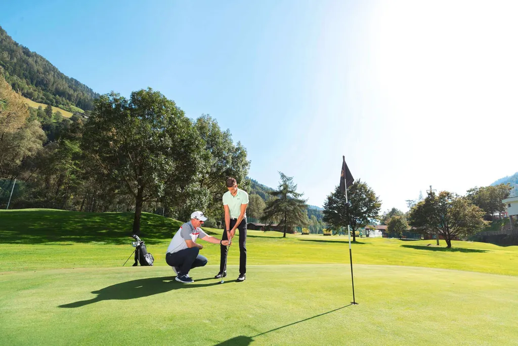 Golfspieler erhält auf dem Golfplatz Anweisungen des Trainers