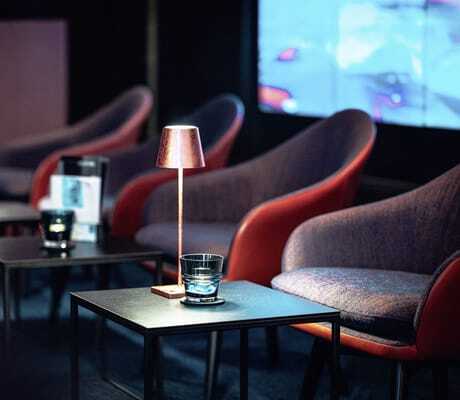 Lounge im Stadthotel Der Blaue Reiter mit Sesseln und stimmungsvollen Leuchten auf den Tischen