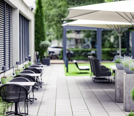 Sommerlounge im Hotel Der Blaue Reiter mit mehreren Sitzmöglichkeiten und Sonnenschirmen