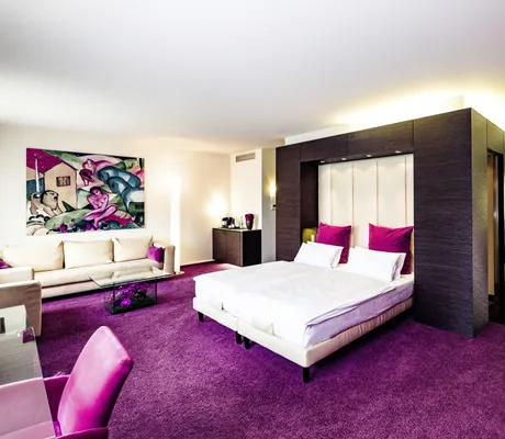 Stilvoll eingerichtete Suite im Stadthotel Der Blaue Reiter mit pinken und grünen Farbakzenten