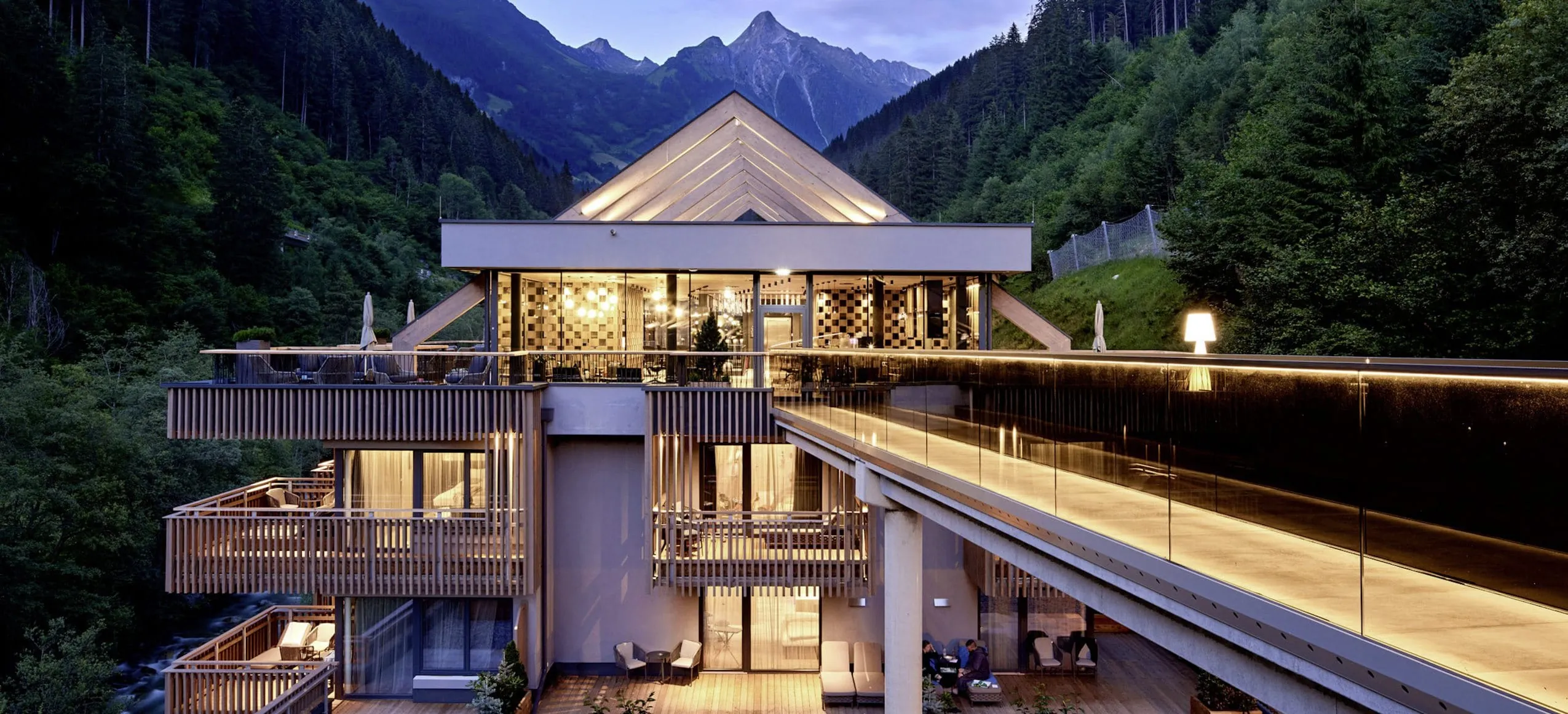 verglaste Br&uuml;cke zum Rooftopspa des ZillergrundRock am Abend