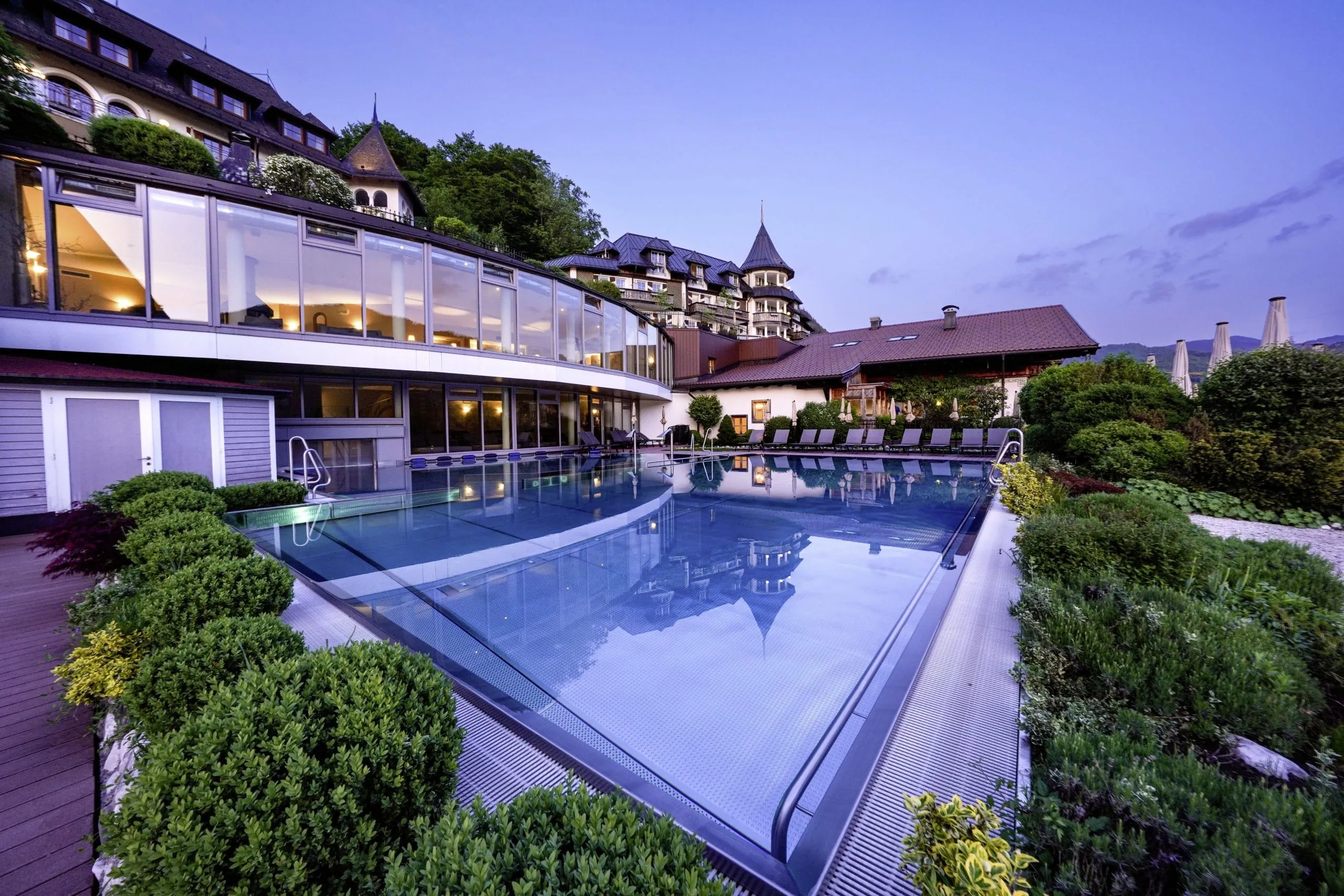 Outdoorpool vor dem Wellnesshotel Ebner&rsquo;s Waldhof am See in der D&auml;mmerung