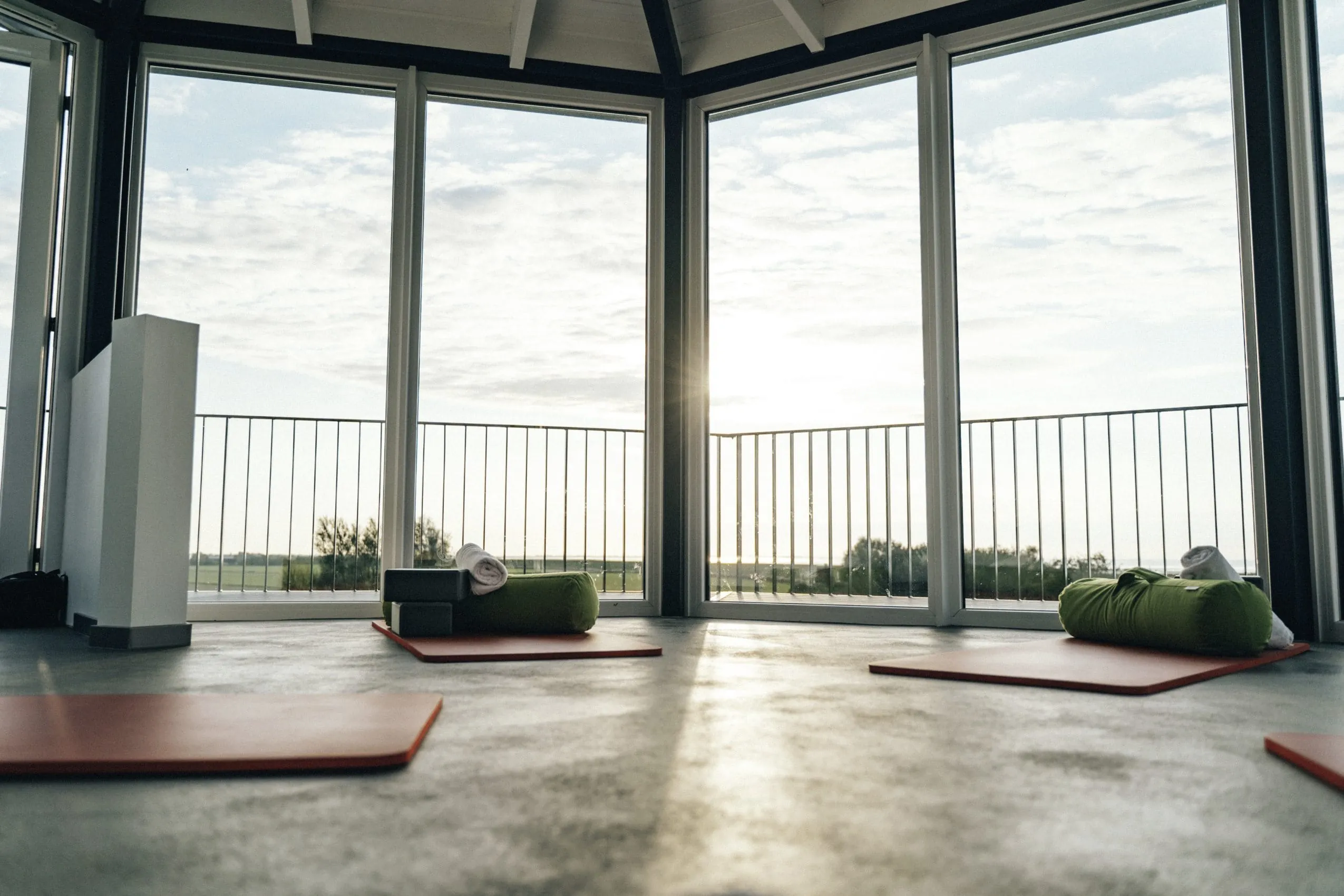 Yogamatten mit Kissen und Bl&ouml;cken im verglasten Leuchtturm-Spa des Lundenbergsand Nordsee Hideaway & SPA