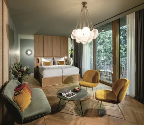 Suite L'Etoile im LA MAISON mit Designerlampe und gelben Stühlen