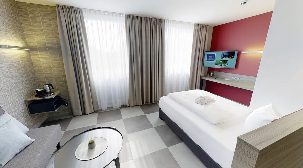 Zimmer mit Einzelbett, Schachbrettboden, beigen Vorhängen und roter Wand