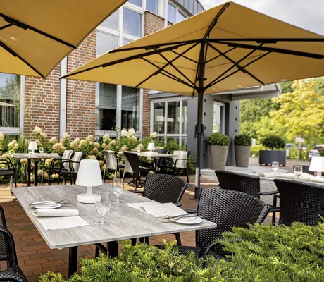 Terrasse im MEDIAN Hotel Lehrte mit gelben Sonnenschirmen