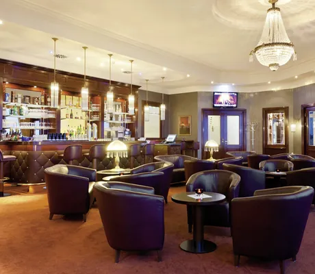 Barbereich im Morada Strandhotel mit dunklen Ledersesseln und Kronleuchter