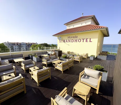 Dachterrasse im MORADA Strandhotel mit Loungemöbeln und Blick aufs Meer