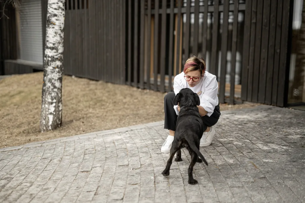 Inhaberin des Naturhotel Pfösl spielt mit kleinem schwarzen Hund