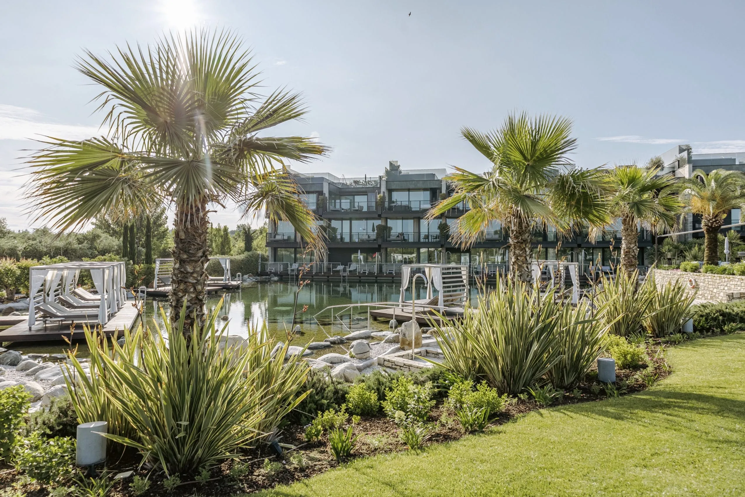 Wellnessgarten des Quellenhof Luxury Resort Lazise mit Palmen und Naturbadeteich