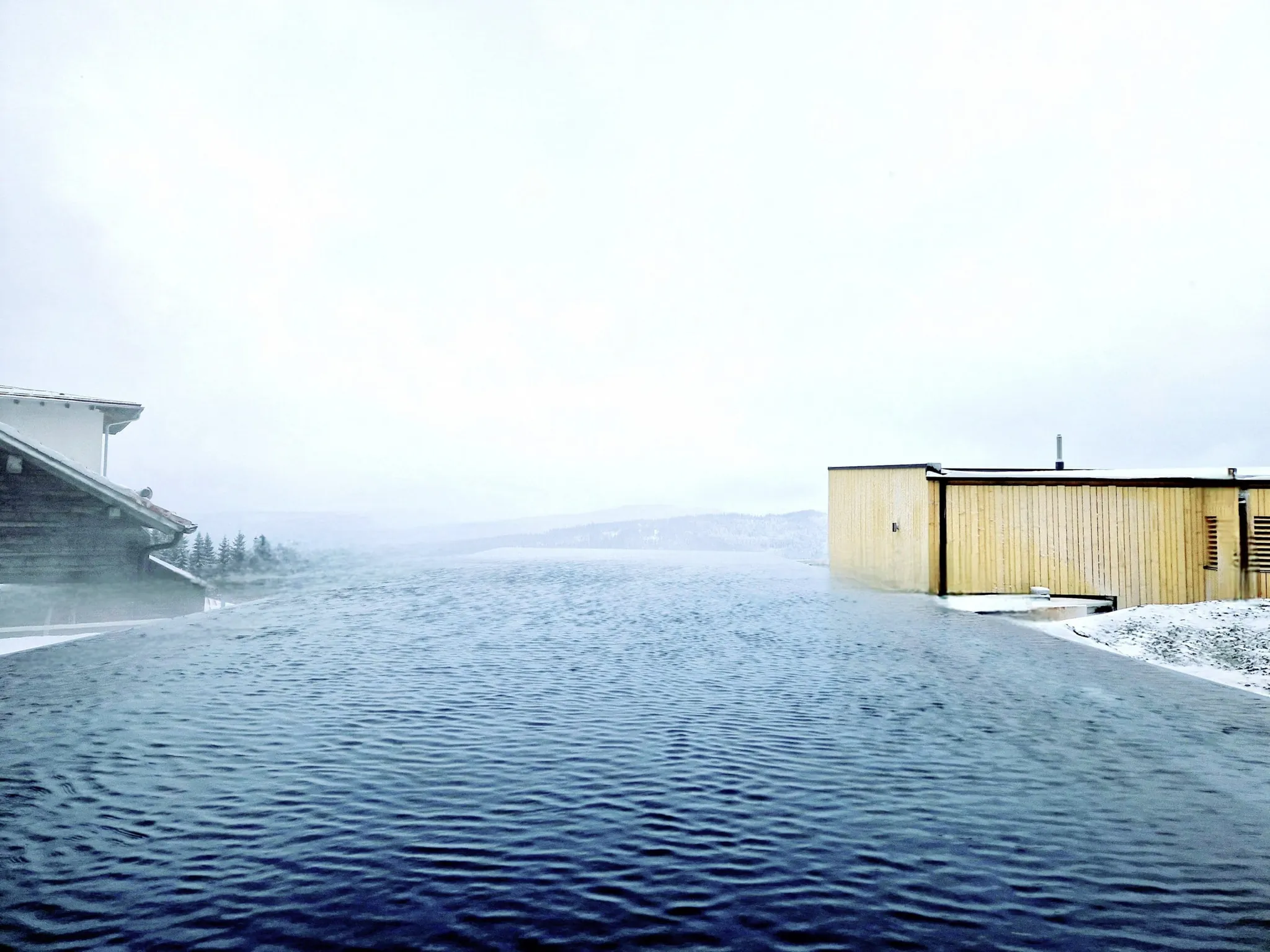 Outdoor-Infinitypool im Winter mit Blick auf den verschneiten Bayerischen Wald