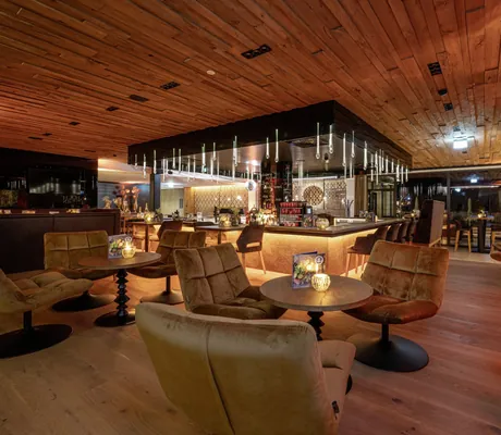 Barbereich in die HOCHKÖNIGIN mit Holzdecke und gelben Drehsesseln