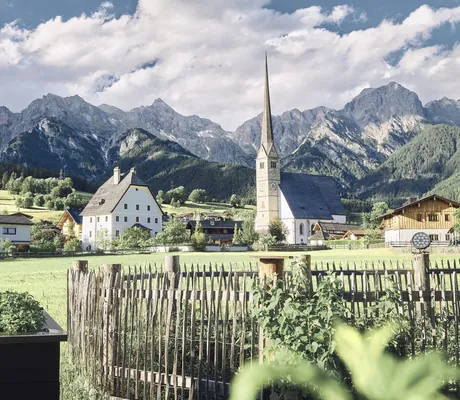 Blick vom Garten im die HOCHKÖNIGIN auf die Kirche von Maria Alm und die Salzburger Berge