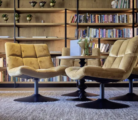 gelbe Drehsessel vor Bücherregal in der Lobby des Hotel die HOCHKÖNIGIN