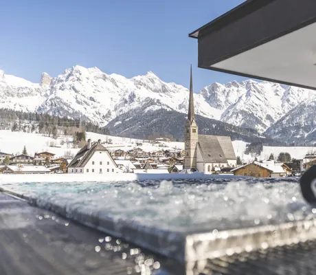 blubbernder Outdoor-Whirlpool auf dem Rooftop des Hotel die HOCHKÖNIGIN im Schnee