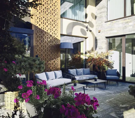 Sitzmöbel auf der Terrasse des Hotel die HOCHKÖNIGIN mit violetten Geranien