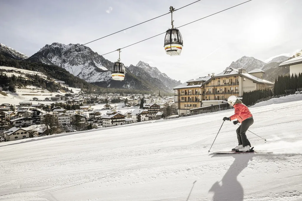 weiße Skipiste mit Skifahrerin im Excelsior Dolomites