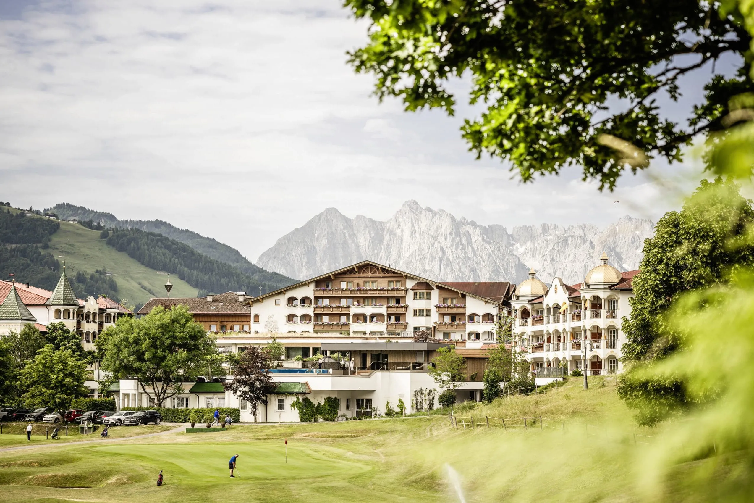 Außenansicht des Peternhof Wohlfühlresort mit Bergpanorama und Golfplatz