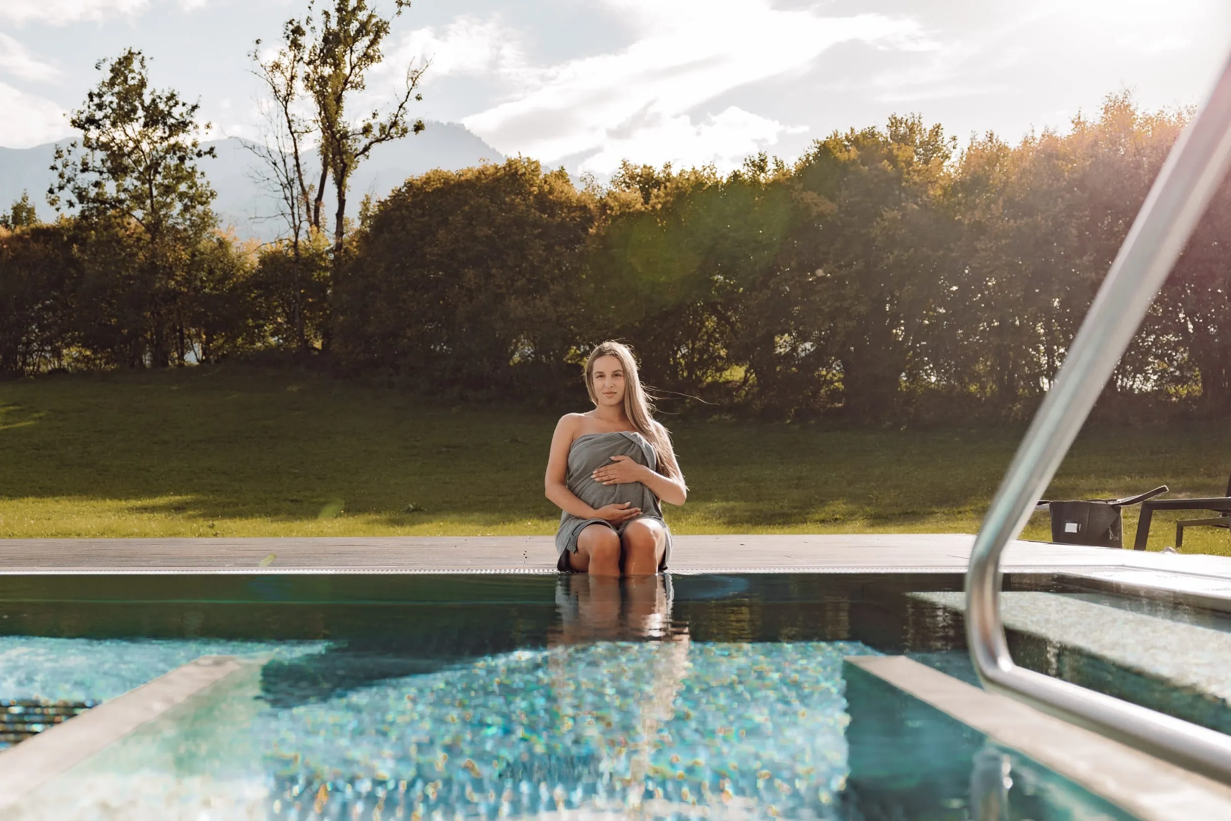 Schwangere sitzt am Outdoorpool des Klosterhof Alpine Hideaway & Spa