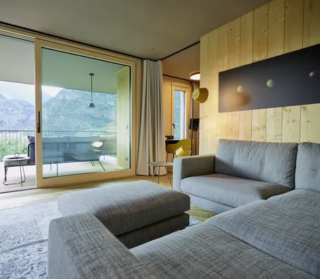 Blick vom Wohnrauf des Chalets auf den Balkon und die umliegende Bergwelt