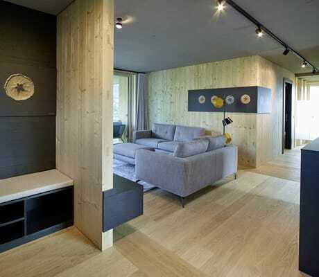 Großzügiger Wohnraum im Gala Lodge mit zwei Sofas und schwarzen Farbakzenten