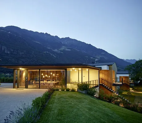 Beleuchteter Gemeinschaftsraum mit großem Tisch und kleiner Bibliothek in den Cirna Gentle Luxury Lodges