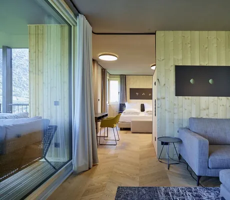 Blick vom Wohnraum mit Sofa in das Schlafzimmer in der Loft Lodge